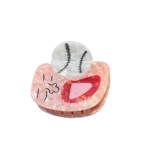 Pince à cheveux en acétate rose marbré avec motif baseball blanc sur fond blanc épuré