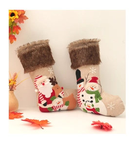 Close-up of burlap Christmas stocking featuring 3D plush embroidery and furry trim