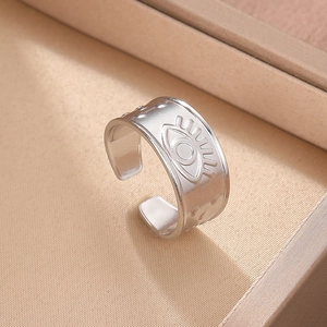 Macro shot of silver adjustable evil eye ring with matte brushed finish on satin