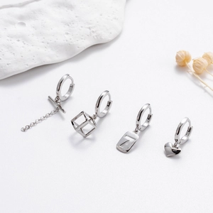 Minimalist silver hoop earrings set with heart, cube, chain and number pendants