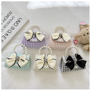 Detailed macro view of girls mini pearl bags with lace bows and houndstooth texture