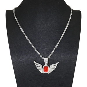 Exaggerated silver angel wing pendant with ruby gemstone on black velvet mannequin