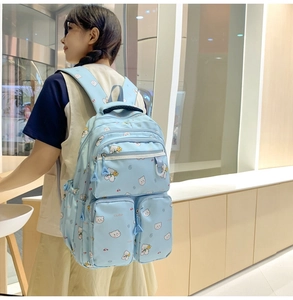 Side view of light blue bear print backpack with multi-zipper pockets on model