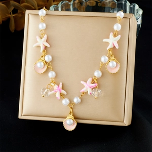 Detail of beaded necklace with gold starfish and shell pendants on display box