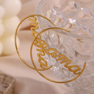 Detail view of 18K gold plated hoop earrings with engraved mama lettering detail