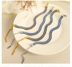 Gros plan de bracelets à triple rangée de cristaux bleus plaqués or 18 carats et argent