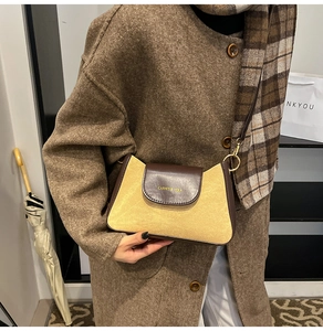 Detail of small leather crossbody bag in dark coffee and yellow with gold hardware buckle