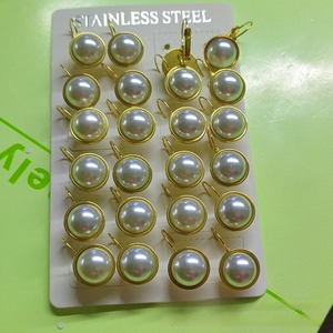 Detail view of 24 pairs of gold-plated stainless steel earrings with half-round pearls
