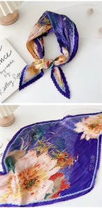 Detailed view of purple floral pleated scarf showing elegant accordion texture and silk fabric