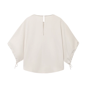 Detail of off-white puff sleeve shirt featuring a decorative cuff tie and hollow back detail
