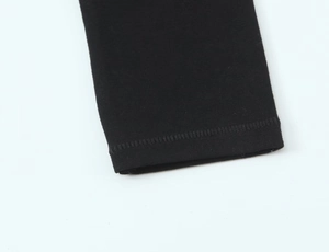 Vue détaillée du revers de manche en coton tricoté noir montrant la texture du tissu