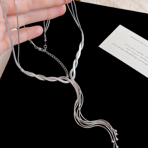 Detail of multi-strand silver tassel necklace with snake chains and metallic beads