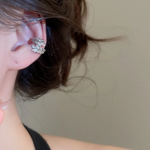 Macro side view of a model wearing a silver leaf-shaped ear cuff with sparkling zircons