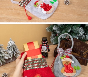 Detailed view of red and grey felt Christmas gift bags with 3D snowman and elk patches