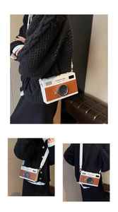Detail of camera-shaped crossbody bag with white and brown PU leather stitching