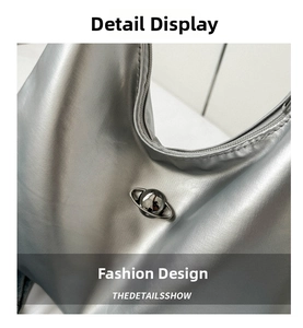 Detailed macro view of metallic silver shoulder bag featuring a planet-shaped metal buckle