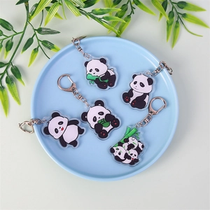 Set of five cute cartoon panda acrylic keychains with metal clasps on a blue display plate