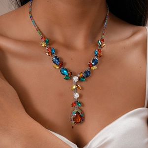 Close-up of model wearing luxury multicolor zircon leaf and teardrop pendant necklace