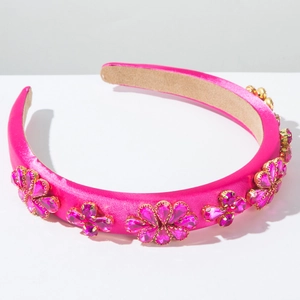 Détail du serre-tête en satin rose avec motifs floraux en strass et rembourrage en éponge douce