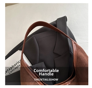 Close-up of brown suede tote bag with leather straps on a white textile surface