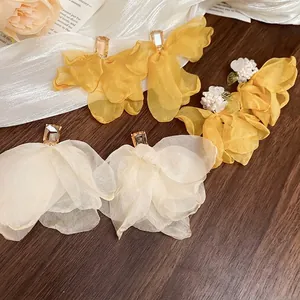Exquisite fabric mesh flower earrings with zircon studs for women on wood background