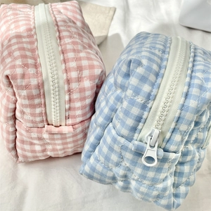 Dettaglio di pochette trucco a quadretti trapuntati rosa e blu con chiusura zip