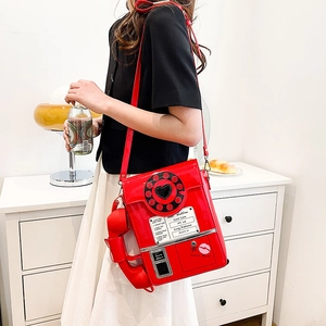 Macro shot of a red vintage telephone crossbody bag with a heart-shaped rotary dial detail