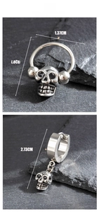 Macro view of vintage skull drop earrings with dimensions in centimeters on stone background