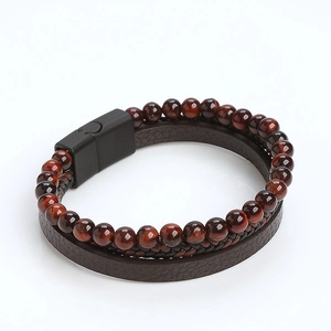 Detail of red-brown natural stone beads and braided leather bracelet with magnetic clasp