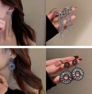 Detailed close-up of silver bow tassel earrings with sparkling rhinestone fringe details