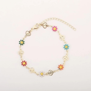Detail of gold daisy bracelet with colorful enamel flowers and hollow heart charms