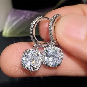 Macro shot of cushion cut zircon drop earrings with pave set halo in silver finish