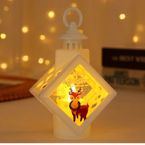 Close-up of white LED Christmas lantern with reindeer print and warm yellow glow light