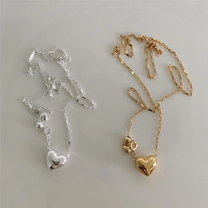 Detail of gold and silver sterling silver heart necklaces with polished link chains