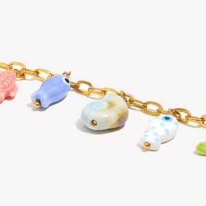 Detailed close-up of 18K gold plated necklace with colorful ceramic sea creature charms