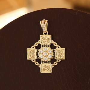 Detail of gold Celtic cross pendant with micro-pave cubic zirconia and black accents