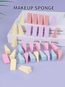 Close-up of colorful wedge-shaped makeup sponges arranged on a decorative book