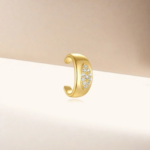 Macro shot of gold C-shaped ear cuff featuring sparkling cubic zirconia inlays