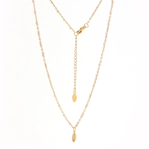 Detailed view of a gold feather pendant with soft pink beads on a minimalist necklace