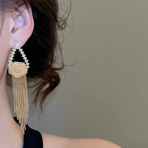 Detail of gold-plated rose flower earrings with cascading zircon tassel fringe
