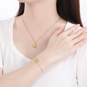 Golden sea shell pendant necklace and bracelet set worn by a female model