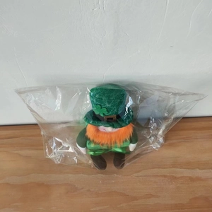 Saint Patrick's Day Leprechaun plush with green sequin hat in protective plastic wrap