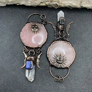 Retro bohemian sun and moon pendants with rose quartz and crystal pillars on black background