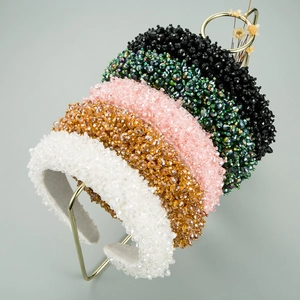 Detail of five multi-colored beaded headbands on a metallic stand for high top styling