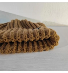 Gros plan sur la texture en tricot côtelé marron épais révélant le détail du fil doux