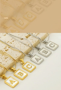 Detailed macro view of 18K gold and silver stainless steel shell initial necklaces