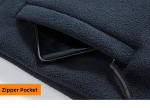 Dettaglio della profonda tasca con cerniera su giacca in pile blu con cellulare