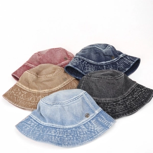 Vintage washed denim bucket hats in five colors with metal logo badge detail