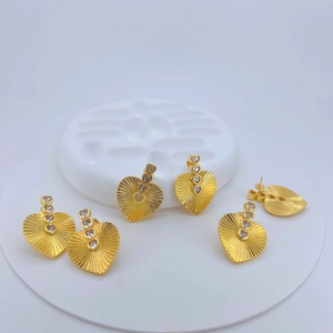 Detail of vintage heart earrings with sunburst texture and micro-pave cubic zirconia