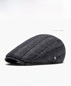 Detailed view of navy blue flat cap featuring vintage herringbone texture and metal logo